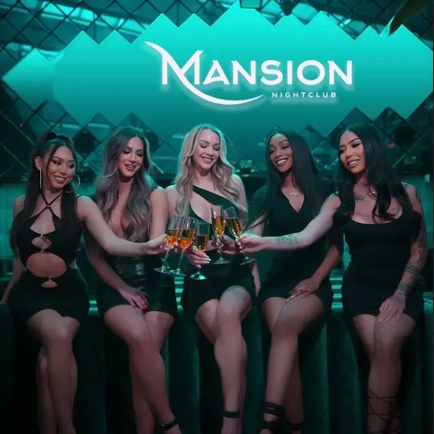 Mansion Nightclub bottle servers sitting and holding and cheersing glasses of champagne