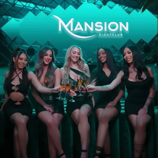 Mansion Nightclub bottle servers sitting and holding and cheersing glasses of champagne
